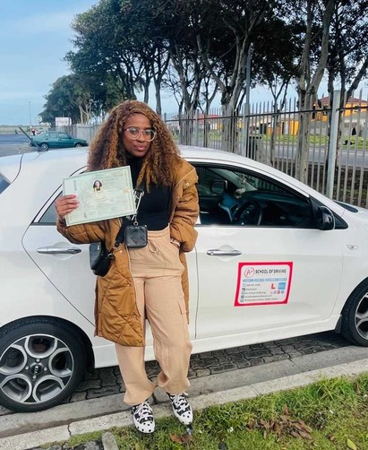 A+ learner celebrating beside an A+ training car